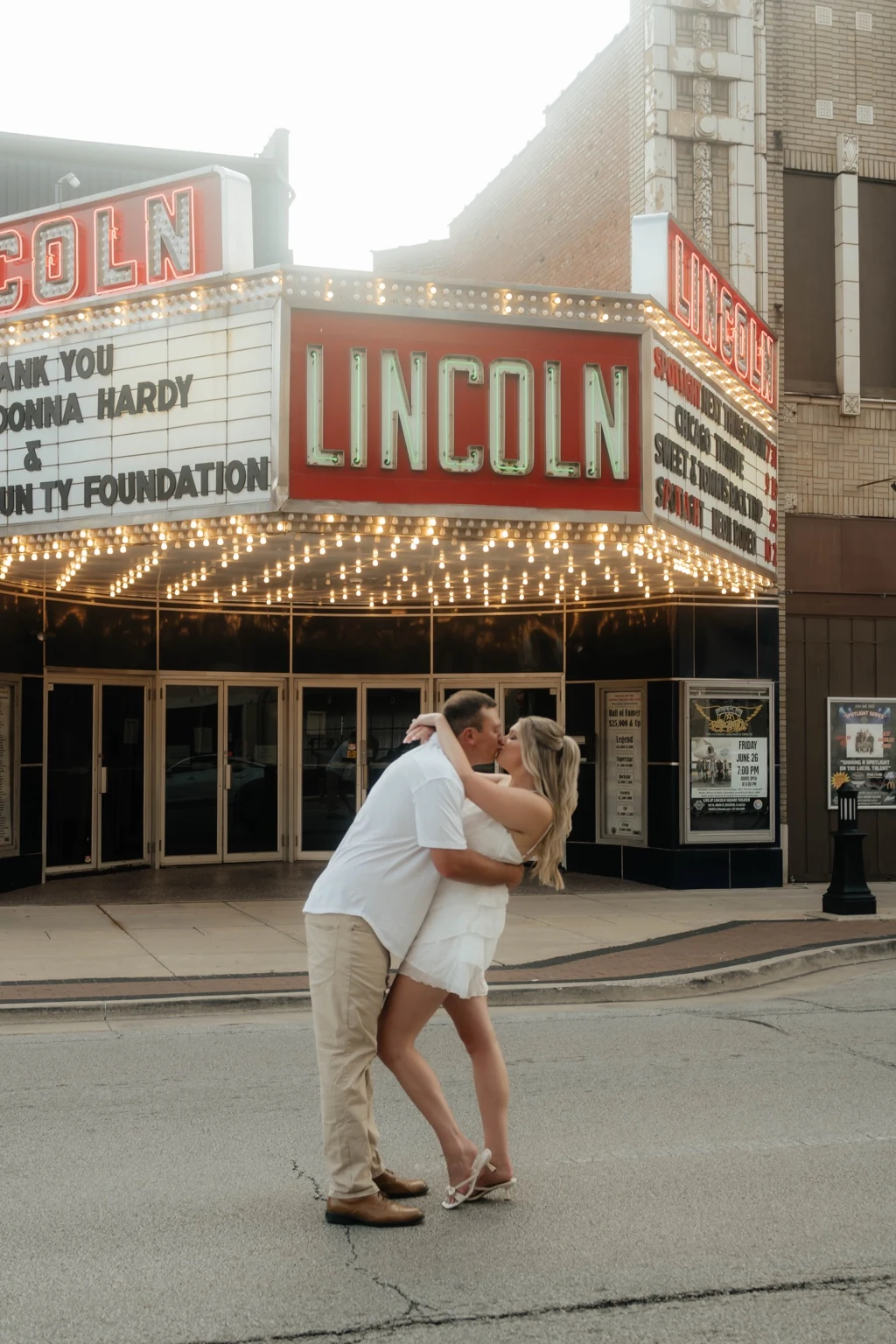 Marissa and Kyle kissing in front of the Lincoln marquee